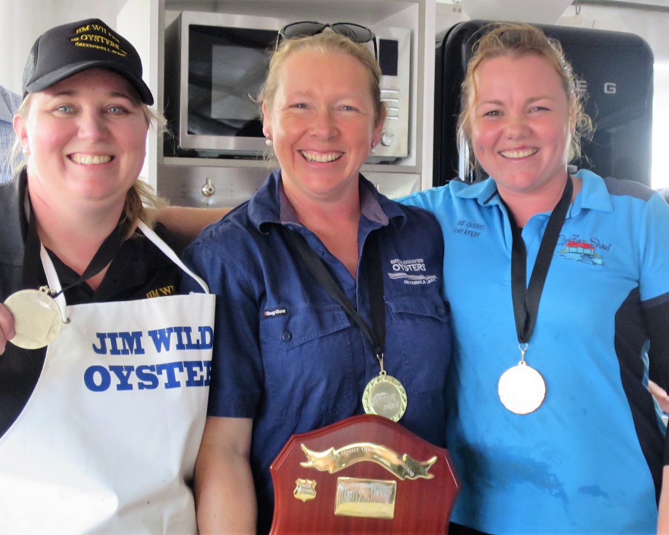 2019 Three women stand, each has a medal and the woman in the middle has a shield. They are Sally McLean, Sue McIntyre and Jade Norris