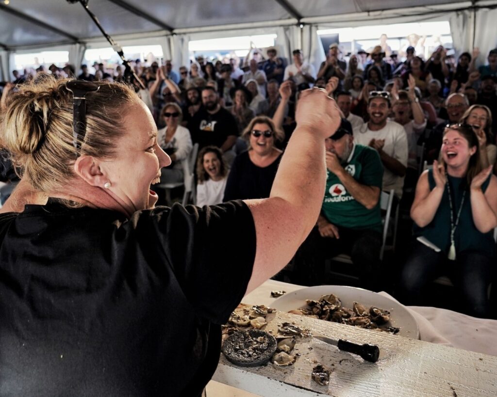 Champion Shucker Sally McLean raises her hands in victory after shucking her 30 oysters to win?