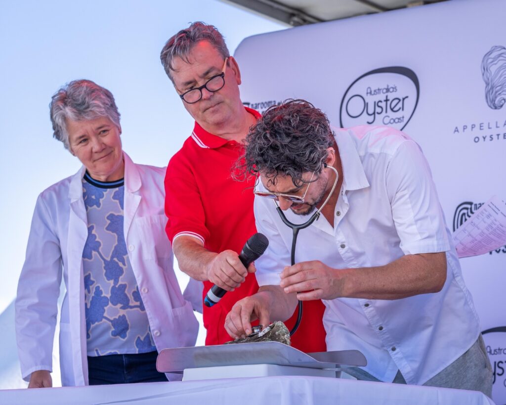 Dr Kate, ABC Radio's Simon Marnie and Chef Colin Fassnidge check weigh an oyster.